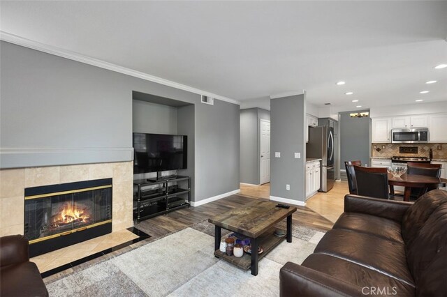 4 Chisholm Trl, Trabuco Canyon, CA 92679 - living area with light wood finished floors, a tile fireplace, baseboards, recessed lighting, and ornamental molding