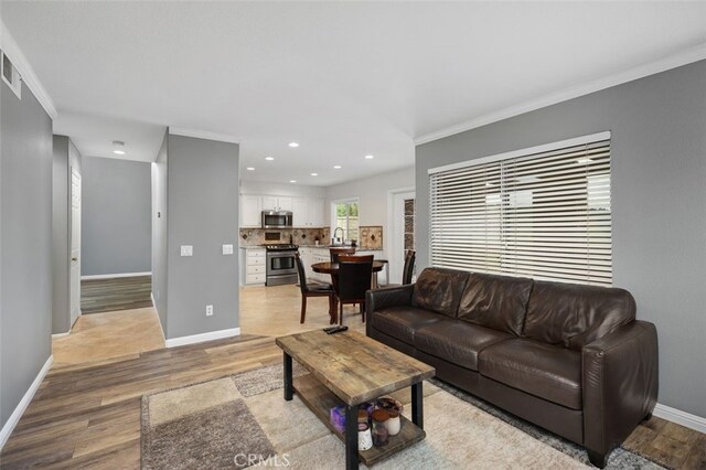4 Chisholm Trl, Trabuco Canyon, CA 92679 - living area featuring light wood-style flooring, baseboards, recessed lighting, and crown molding