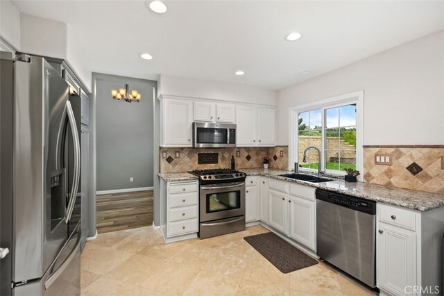 4 Chisholm Trl, Trabuco Canyon, CA 92679 - kitchen with stainless steel appliances, a sink, light stone counters, white cabinets, and recessed lighting