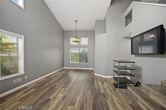 4 Chisholm Trl, Trabuco Canyon, CA 92679 - unfurnished living room with wood finished floors, a high ceiling, a chandelier, and baseboards