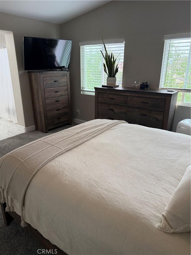 bedroom with carpet floors, lofted ceiling, and baseboards