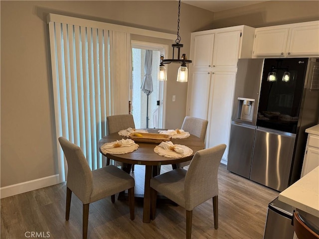 dining room featuring light wood-type flooring and baseboards
