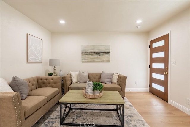 living room with baseboards, recessed lighting, and light wood-style floors