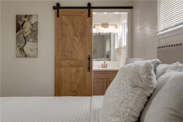 bedroom with a barn door and ensuite bath