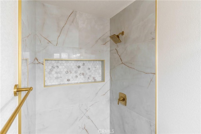 bathroom featuring a marble finish shower