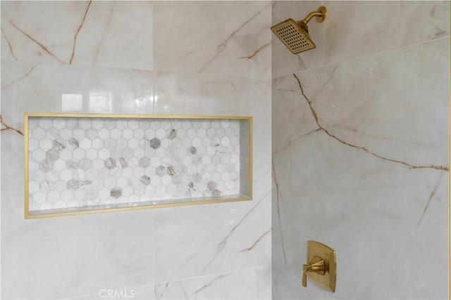 interior details featuring tiled shower