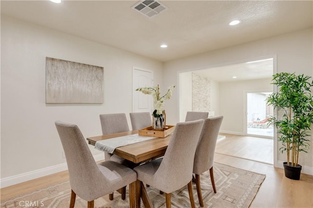 dining area featuring light wood finished floors, baseboards, visible vents, and recessed lighting