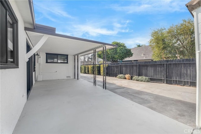 view of patio with fence and an attached carport