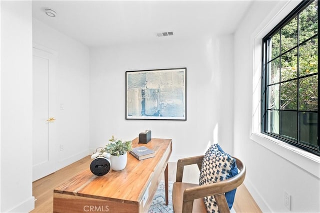 office featuring wood finished floors, visible vents, and baseboards