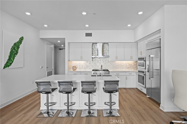 3713 Rivington, Irvine, CA 92612 - kitchen with wall chimney range hood, light countertops, white cabinetry, tasteful backsplash, and appliances with stainless steel finishes