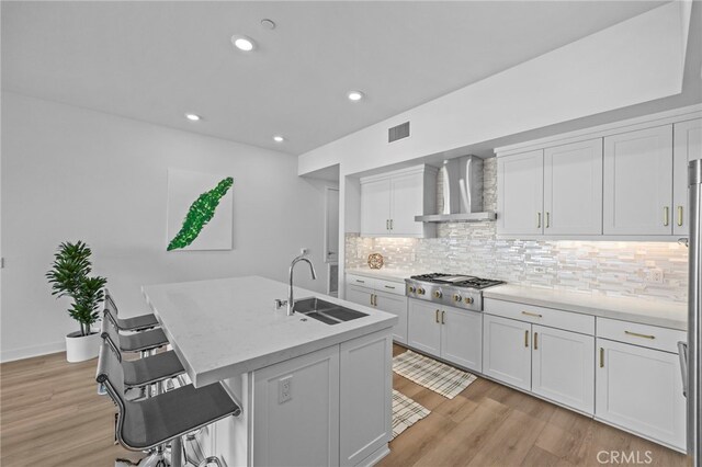 3713 Rivington, Irvine, CA 92612 - kitchen with a sink, light wood-style flooring, wall chimney exhaust hood, stainless steel gas stovetop, and visible vents