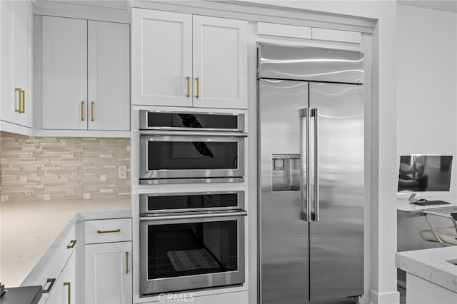 3713 Rivington, Irvine, CA 92612 - kitchen featuring white cabinetry, appliances with stainless steel finishes, backsplash, and light stone countertops