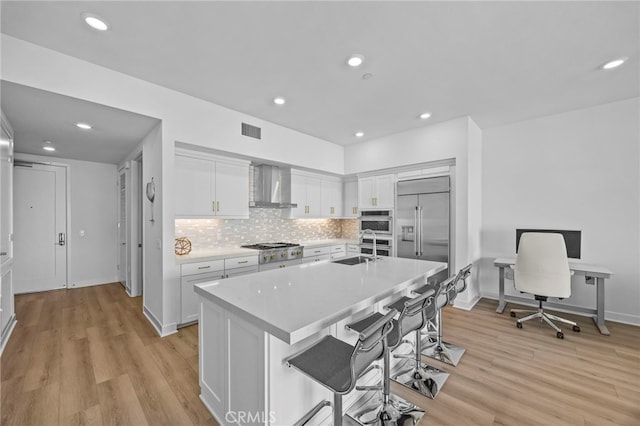 3713 Rivington, Irvine, CA 92612 - kitchen featuring white cabinets, appliances with stainless steel finishes, light countertops, wall chimney exhaust hood, and visible vents