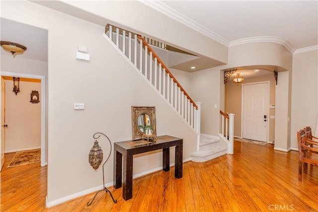 7607 Corona Valley Ave, Eastvale, CA 92880 - entrance foyer with ornamental molding, hardwood / wood-style flooring, stairway, arched walkways, and baseboards