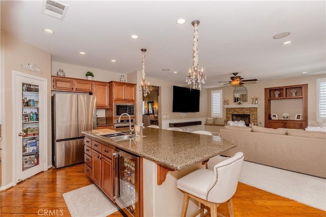 7607 Corona Valley Ave, Eastvale, CA 92880 - kitchen with stainless steel appliances, beverage cooler, a sink, recessed lighting, and a chandelier