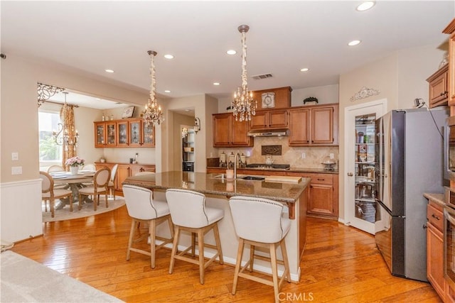 7607 Corona Valley Ave, Eastvale, CA 92880 - kitchen with a chandelier, under cabinet range hood, appliances with stainless steel finishes, light wood-style flooring, and a sink