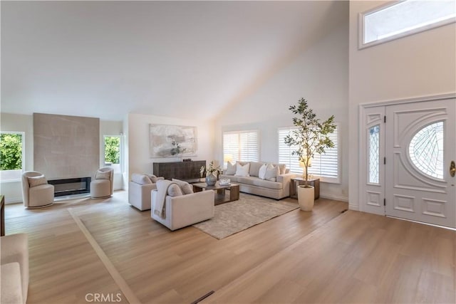 3802 E Summitridge Ln, Orange, CA 92867 - living area with baseboards, high vaulted ceiling, wood finished floors, and a tile fireplace