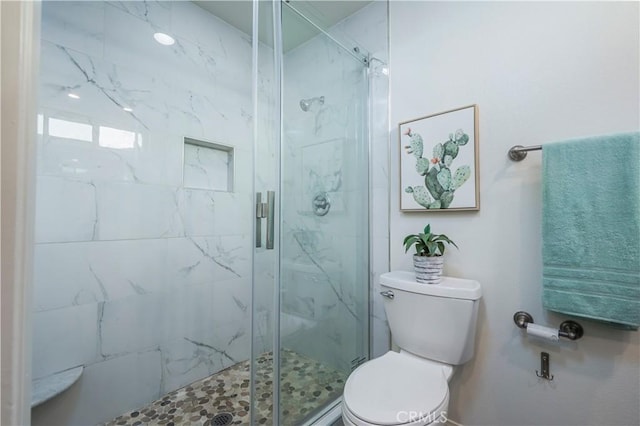 full bathroom with toilet and a marble finish shower