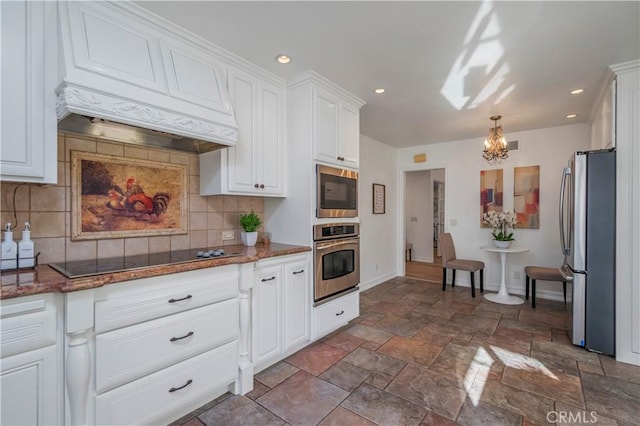 kitchen with black electric cooktop, freestanding refrigerator, decorative backsplash, a chandelier, and white cabinetry