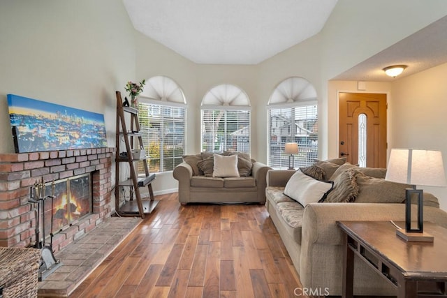 11568 Luanda St, Lakeview Terrace, CA 91342 - living room featuring lofted ceiling, a brick fireplace, wood finished floors, and baseboards