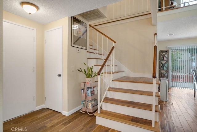11568 Luanda St, Lakeview Terrace, CA 91342 - stairs with wood finished floors, a textured ceiling, and baseboards