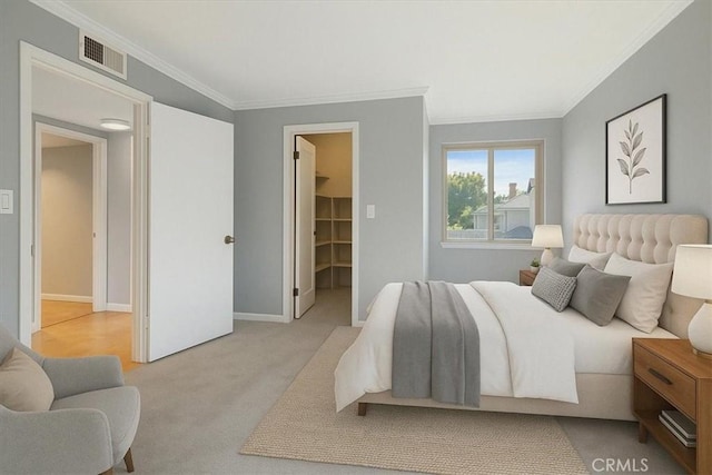 carpeted bedroom with a spacious closet, baseboards, ornamental molding, and visible vents