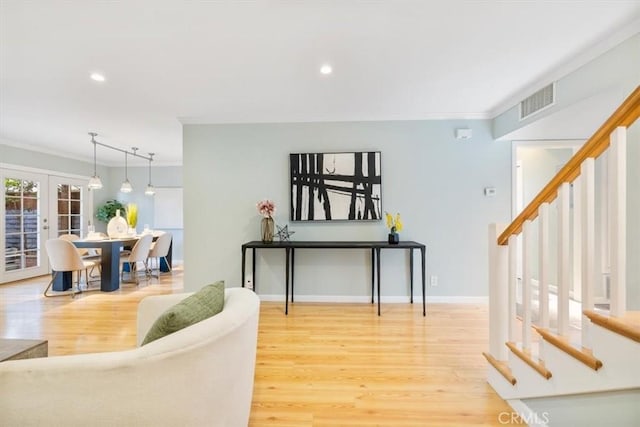 interior space with wood finished floors, stairway, and crown molding
