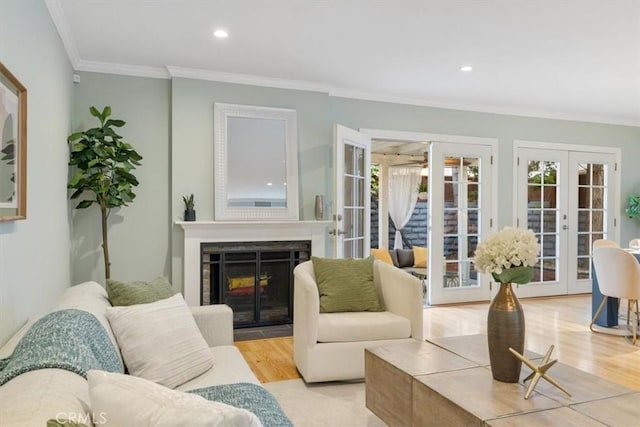 living area with french doors, recessed lighting, wood finished floors, a multi sided fireplace, and crown molding