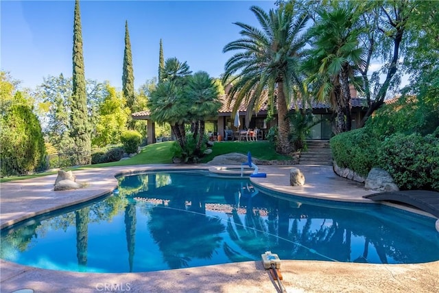 outdoor pool featuring a lawn