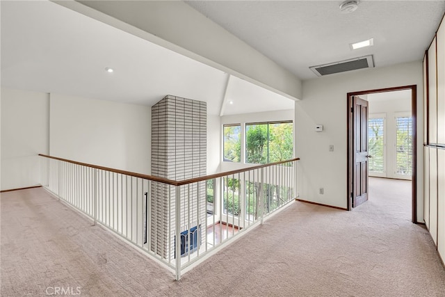 corridor featuring visible vents, carpet flooring, and baseboards