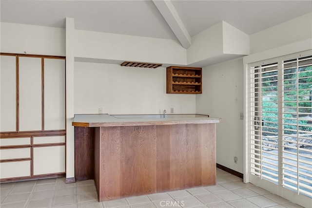 bar with wet bar and beamed ceiling