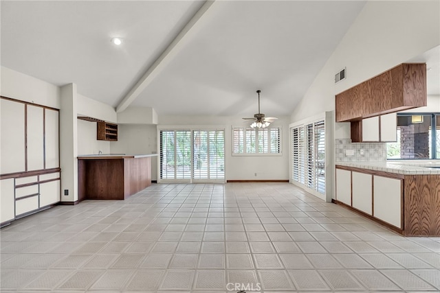 kitchen featuring a ceiling fan, open floor plan, baseboards, tasteful backsplash, and visible vents
