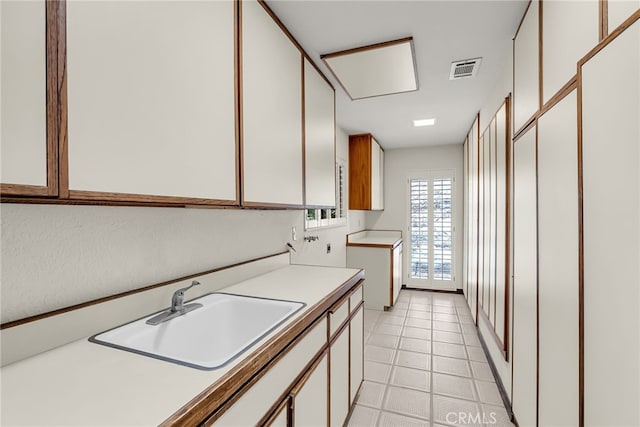 laundry area with cabinet space, visible vents, and a sink
