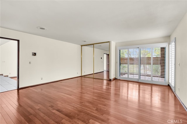 unfurnished room featuring baseboards and light wood finished floors
