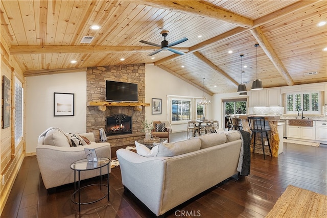 living area featuring wooden ceiling, lofted ceiling with beams, dark wood-type flooring, and a fireplace