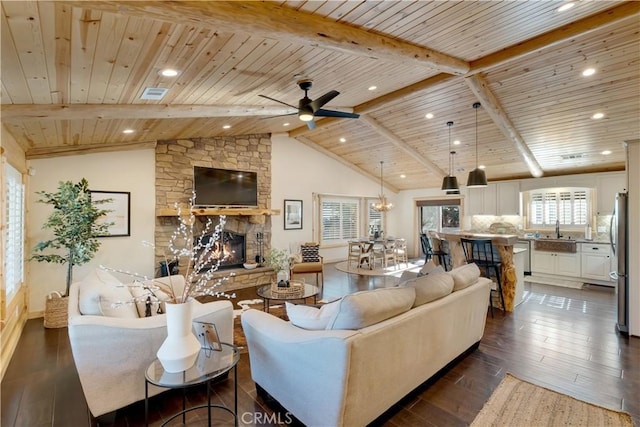 living area featuring wood ceiling, plenty of natural light, visible vents, and a fireplace