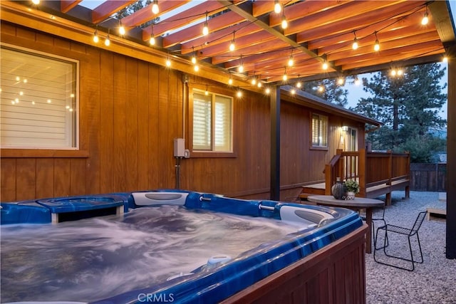 view of side of home with a pergola, a patio area, and a hot tub