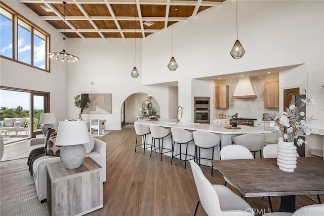 4385 Rainbow Vista Dr, Fallbrook, CA 92028 - dining room with arched walkways, a towering ceiling, wood finished floors, a chandelier, and beam ceiling
