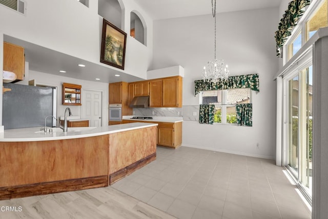964 Vista Pointe Pl, Santa Paula, CA 93060 - kitchen featuring a peninsula, oven, visible vents, freestanding refrigerator, and light countertops