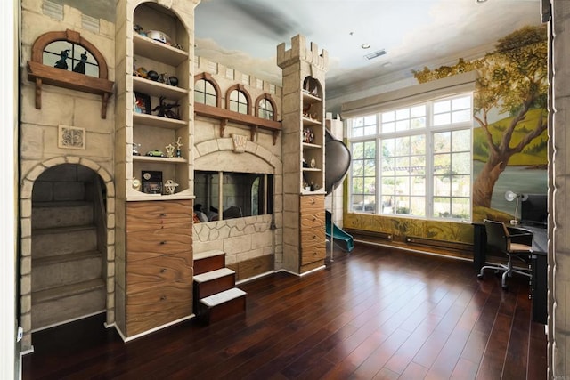 office featuring dark wood finished floors, visible vents, and a fireplace