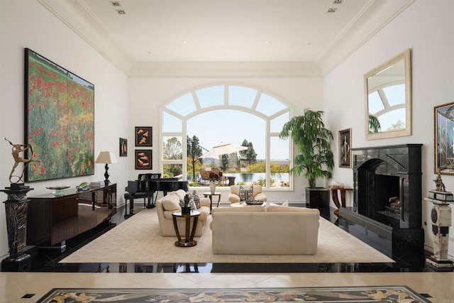 tiled living room featuring a high ceiling, crown molding, a water view, and a fireplace
