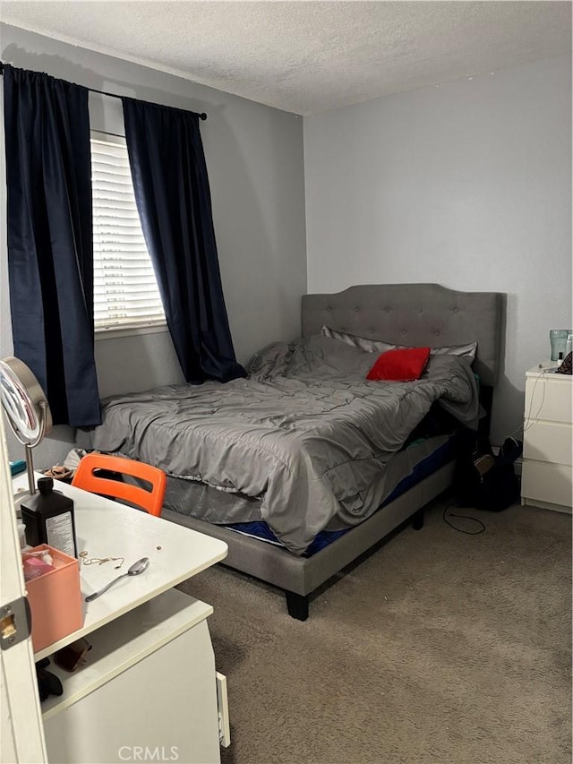 bedroom with carpet floors and a textured ceiling