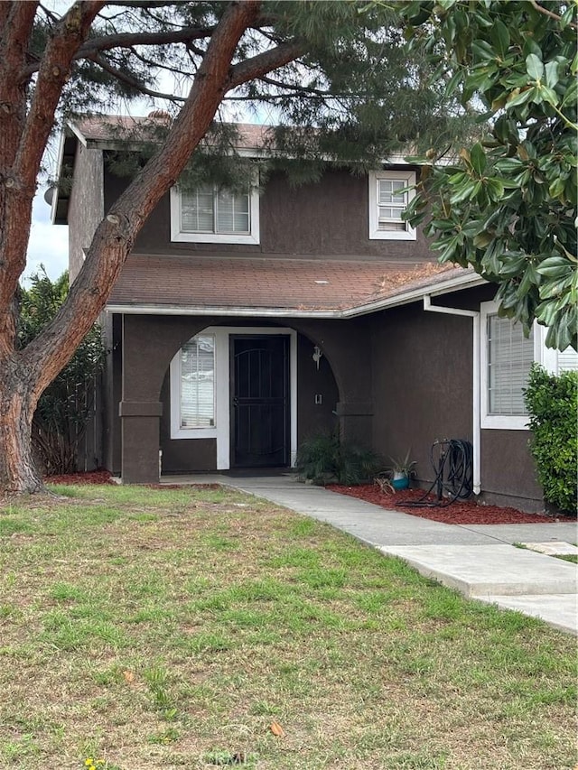view of front facade featuring stucco siding and a front yard