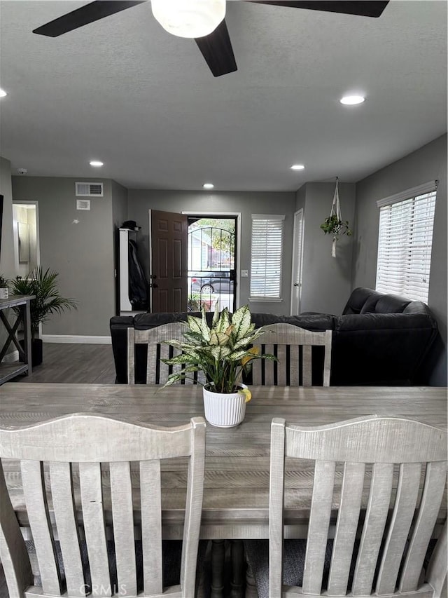 dining room featuring a wealth of natural light, a ceiling fan, wood finished floors, and baseboards
