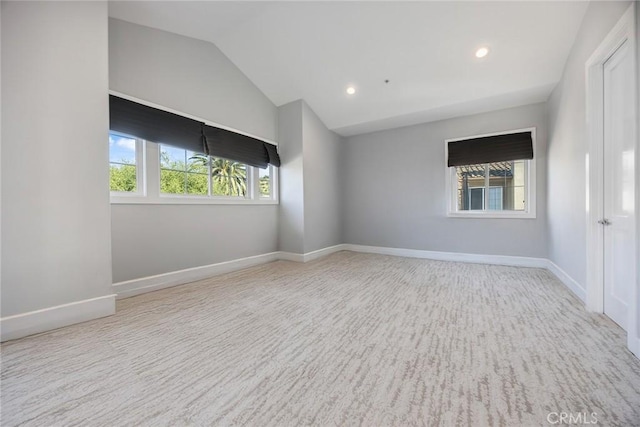 unfurnished room with lofted ceiling, recessed lighting, carpet flooring, and baseboards