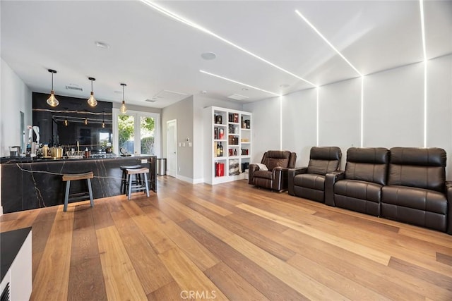 living area with wet bar and wood finished floors
