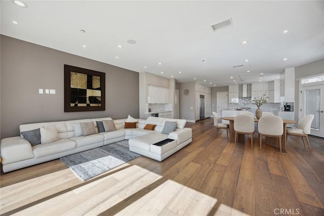 living room featuring visible vents, wood finished floors, and recessed lighting