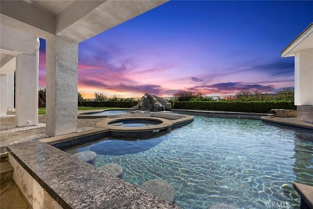 view of swimming pool featuring fence, a fenced in pool, and an in ground hot tub