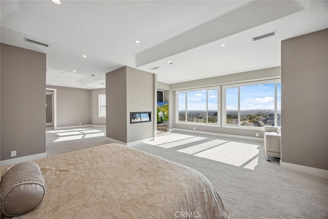 bedroom featuring baseboards, visible vents, carpet, and a glass covered fireplace