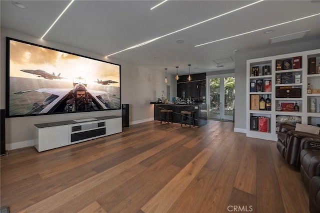 cinema featuring built in shelves, wood finished floors, and baseboards